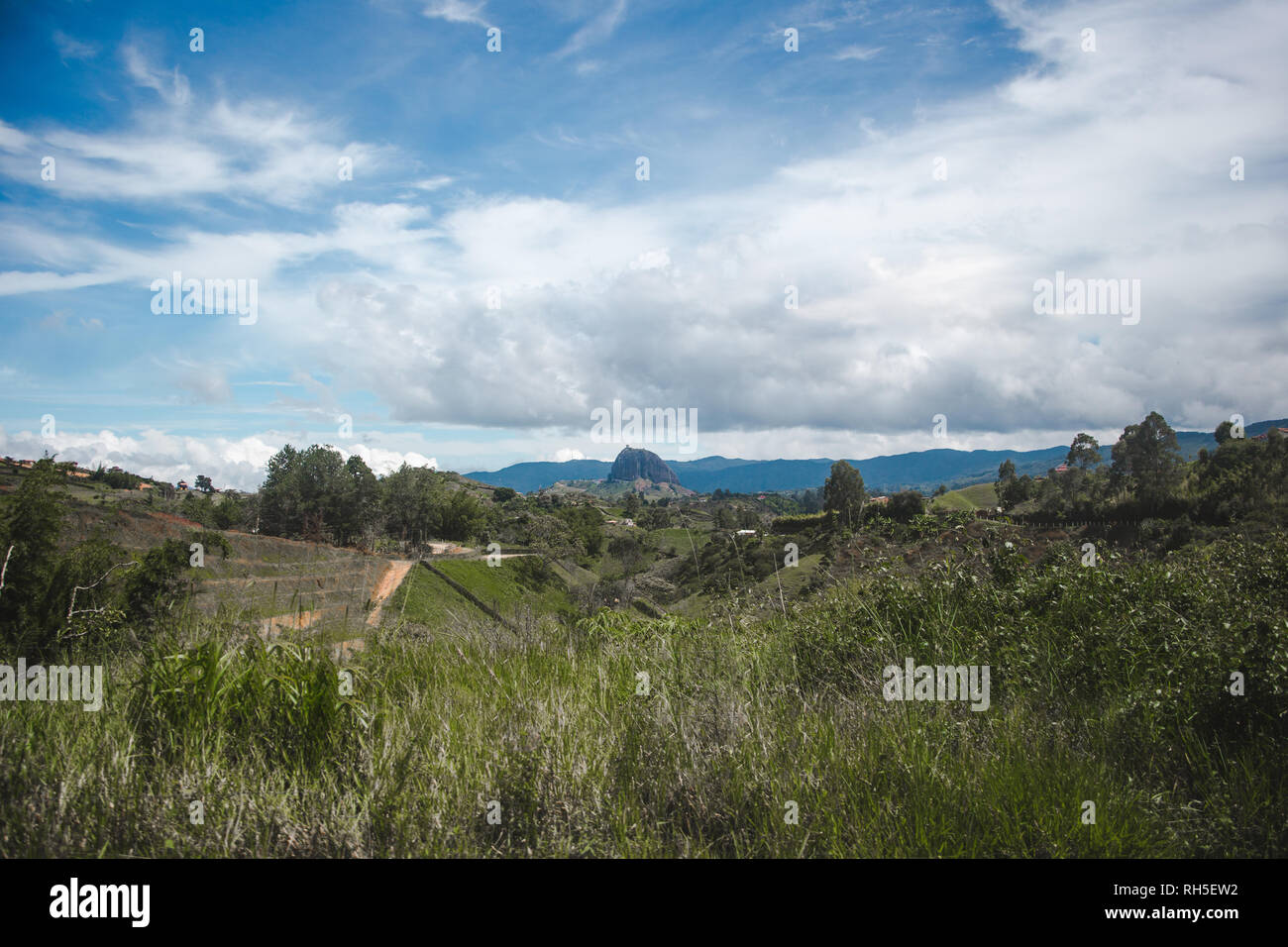 Colombiano di Antioquia campagna con la Guatapé Piedra del Peñol rock visibile dietro il verde delle colline Foto Stock