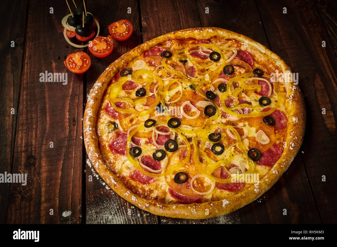 Una deliziosa pizza con verdure e formaggio su di un tavolo di legno Foto Stock