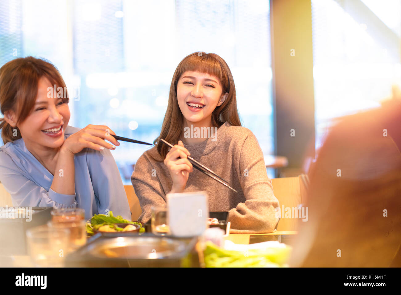 Felice asian giovane gruppo di mangiare nel ristorante Foto Stock