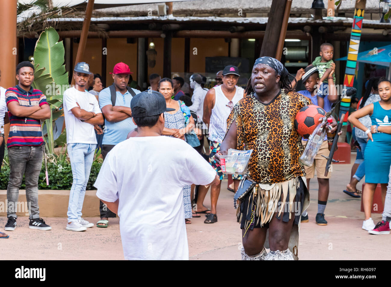 Durban, Sud Africa - Gennaio 6th, 2019: un uomo nero Fire-swallower raccogliendo suggerimenti dopo aver eseguito a fronte spiaggia di Durban, Sud Africa. Foto Stock