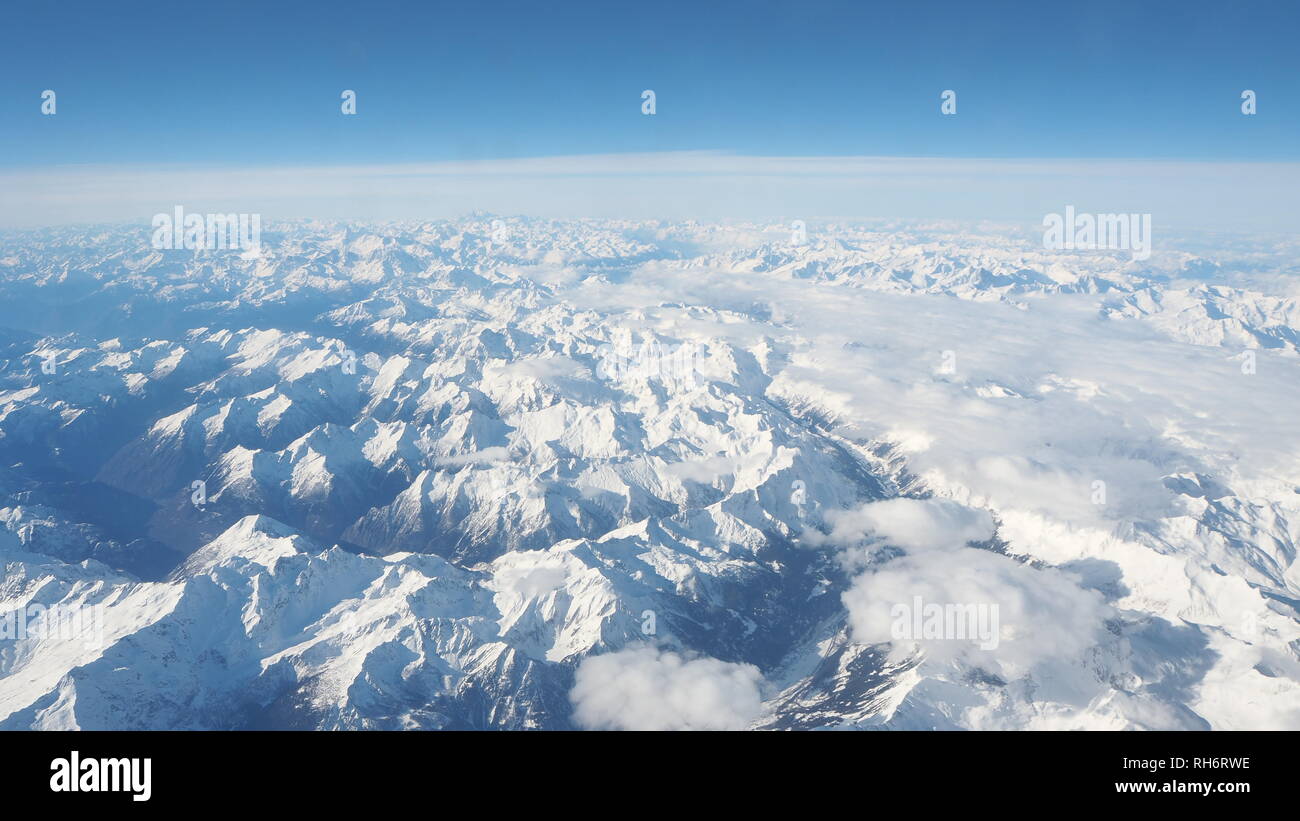 Antenna paesaggio delle Alpi in Europa durante la stagione invernale con neve fresca. La vista dalla finestra dell'aeroplano Foto Stock