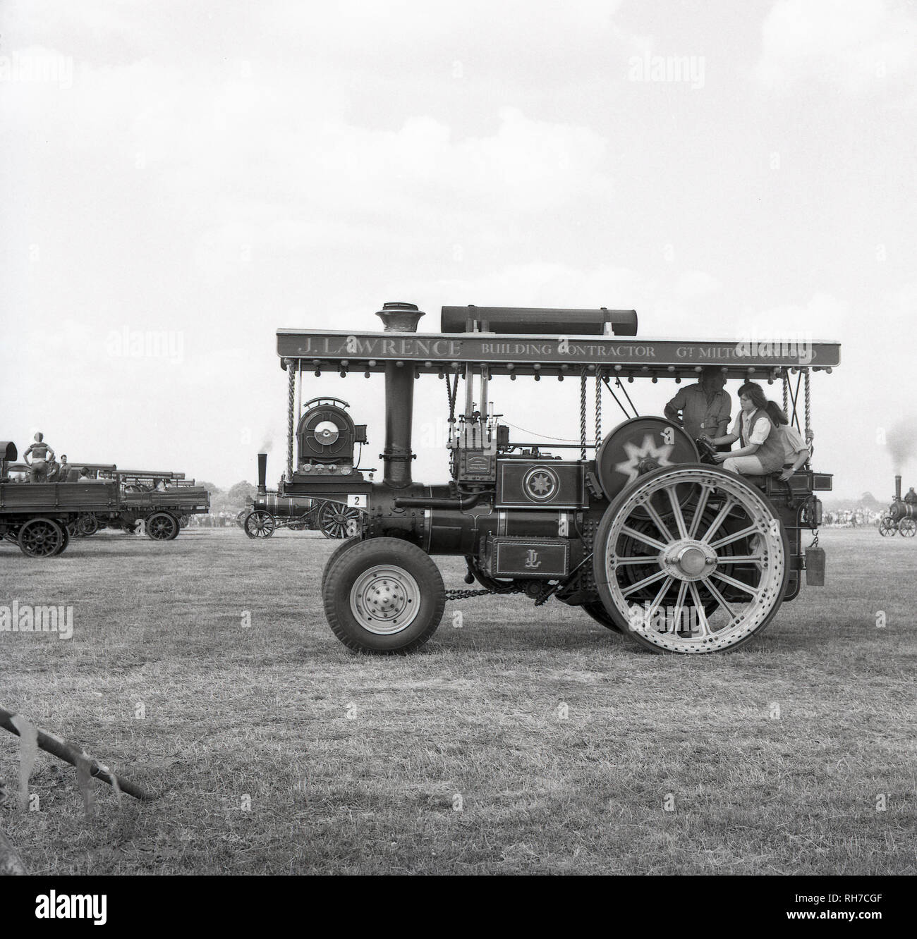 Anni sessanta, ragazzi su un mezzo semovente a restaurata con trazione a vapore motore,con il nome J. Lawrence, Gt. Milton, Oxford. motori a trazione a vapore erano stati sviluppati per spostare carichi pesanti sulle aziende agricole e le altre località rurali invece di animali, principalmente progetti di cavalli e hanno rivoluzionato l'agricoltura. Essi sono stati sostituiti dai trattori che erano più leggeri, più rapidi e più versatile. Foto Stock