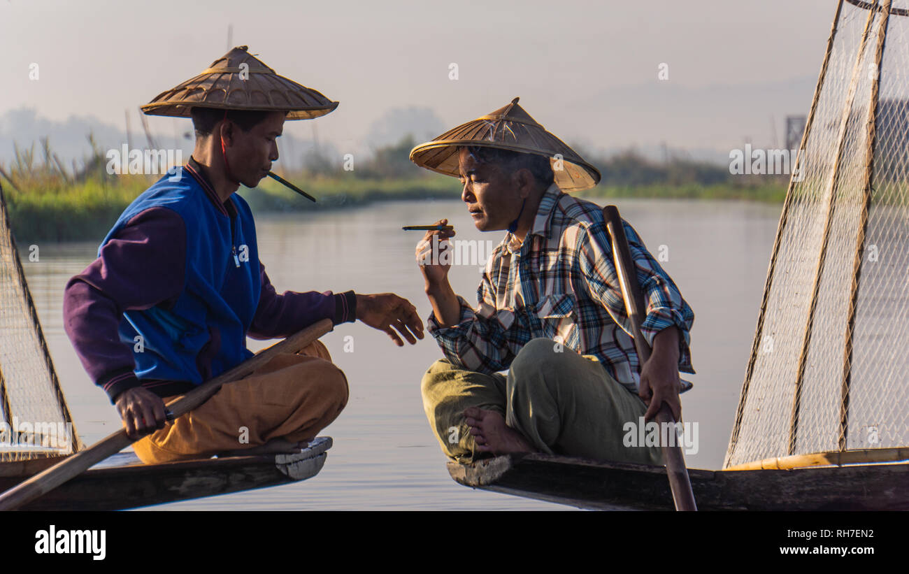 Lago Inle/ Myanmar- gennaio 12,2019: tradizionale di pescatori Intha prendendo una pausa sigaretta con cheroot sigari nelle prime ore del mattino sul lago Inl Foto Stock