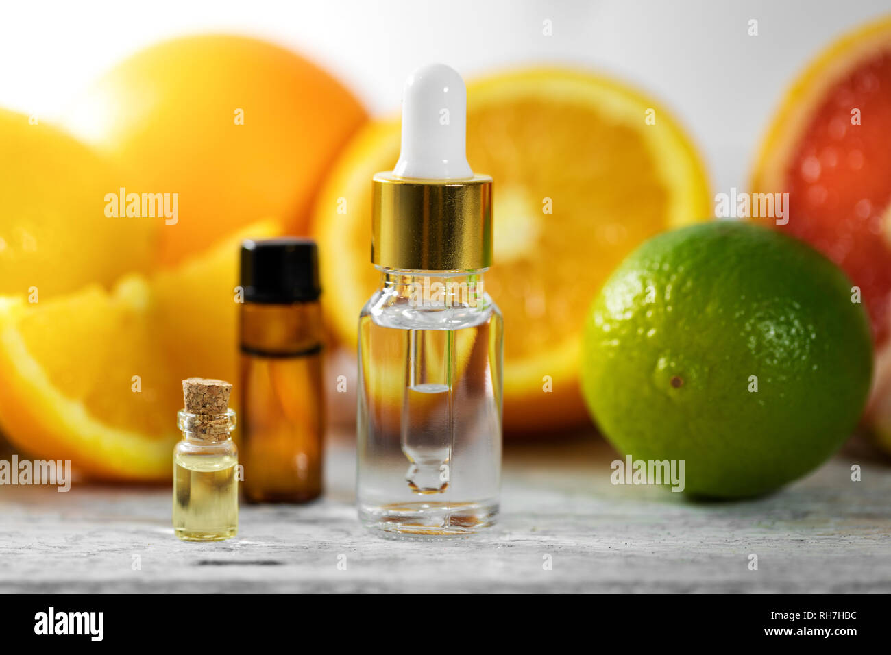 Essenziali biologici le bottiglie di olio e di frutta sul tavolo di legno Foto Stock
