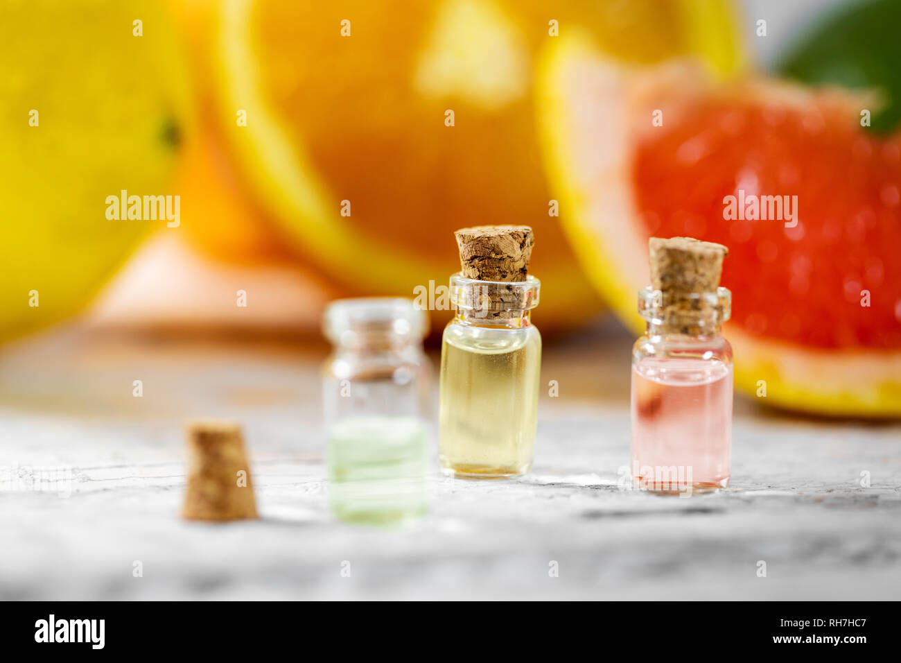 Olio essenziale di agrumi bottiglie su sfondo di frutta Foto Stock