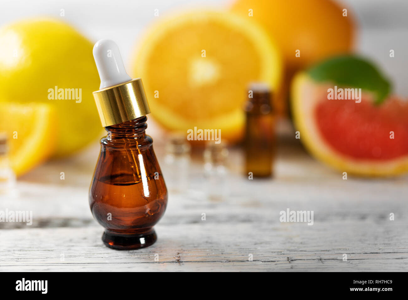 Un trattamento di aromaterapia - frutta olio essenziale bottiglia sul tavolo di legno Foto Stock