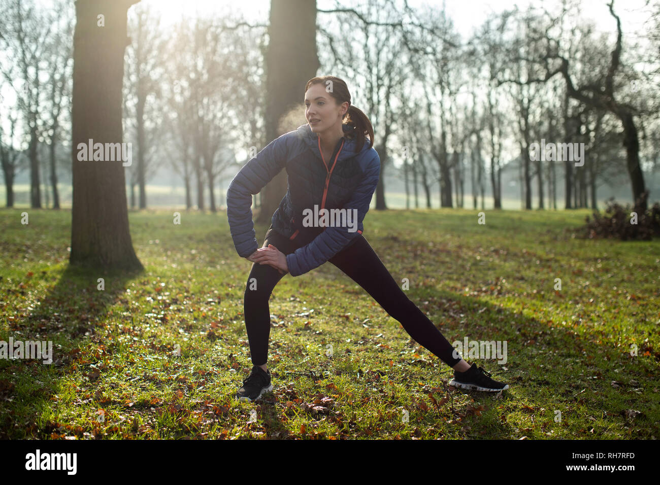 Donna in fase di riscaldamento per la ginnastica mattutina con tratti in Winter Park Foto Stock