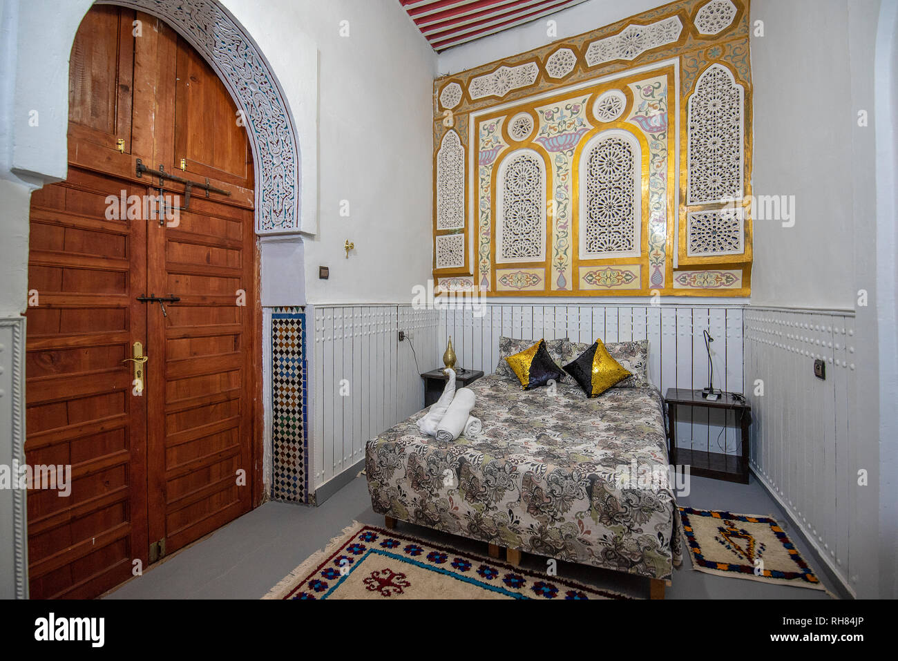 Cortile interno con pareti in piastrelle e pavimento di mosaico. Tradizionale e ornati arabesque colorate sculture a parete nel riad marocchino . All'interno Foto Stock