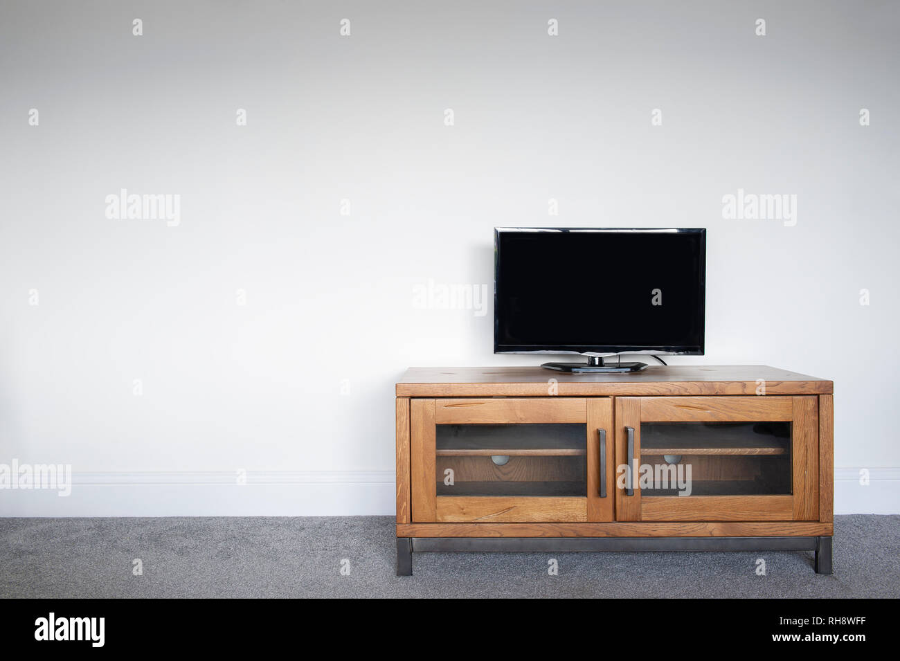 Un industriale del legno e metallo unità TV in un salotto interno contro una normale parete bianca. Foto Stock