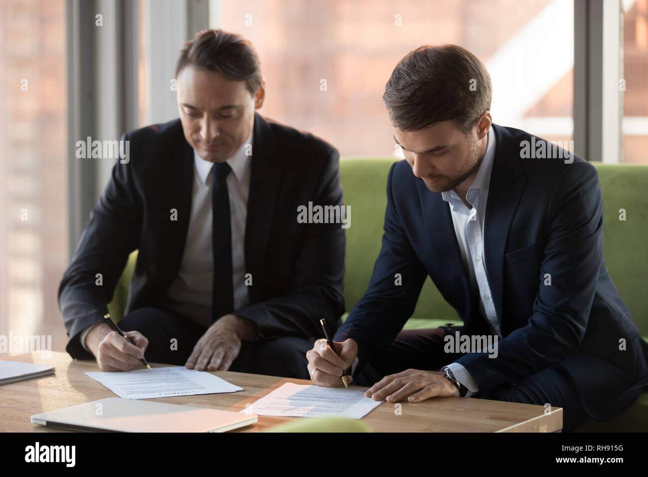 Il successo di due persone di mezza età uomini d'affari in giacca la firma di contratti Foto Stock