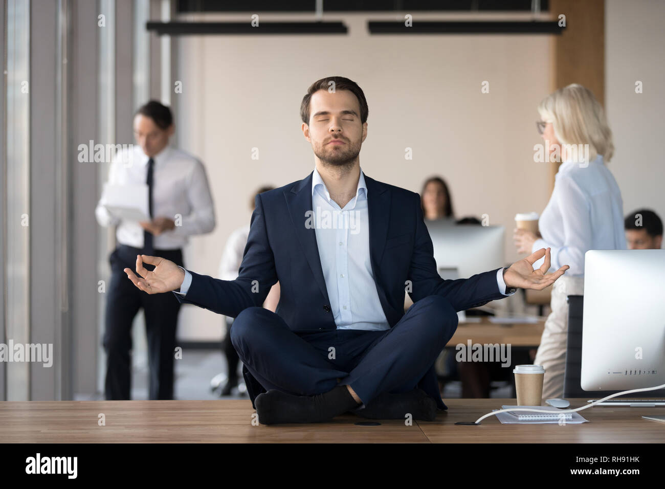 Calma imprenditore nel soddisfare meditando in ufficio sulla scrivania Foto Stock