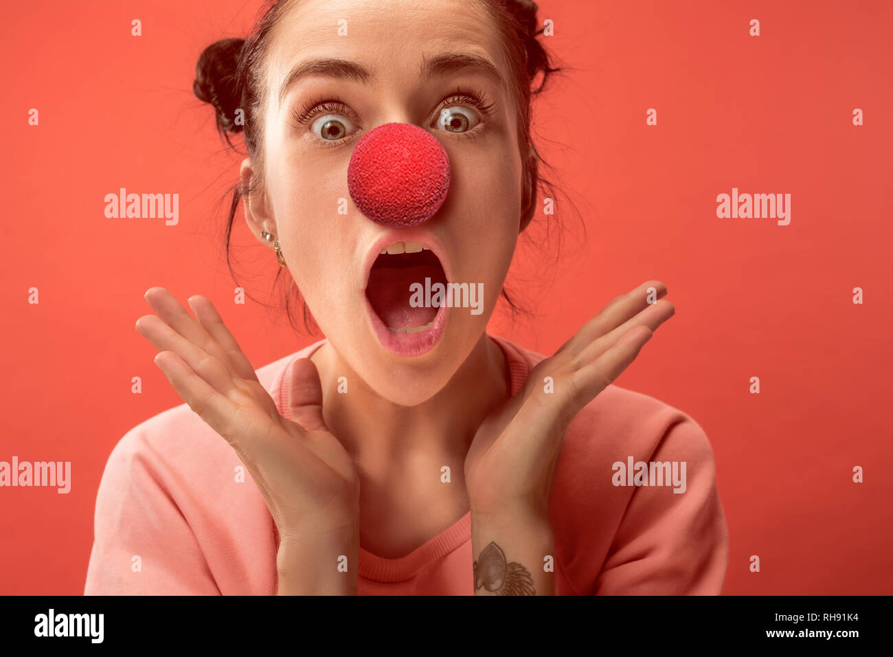 La felice sorpresa e donna sorridente sul naso rosso al giorno. Il clown, divertimento, party, celebrazione, divertente, gioia, vacanze, umorismo concept Foto Stock