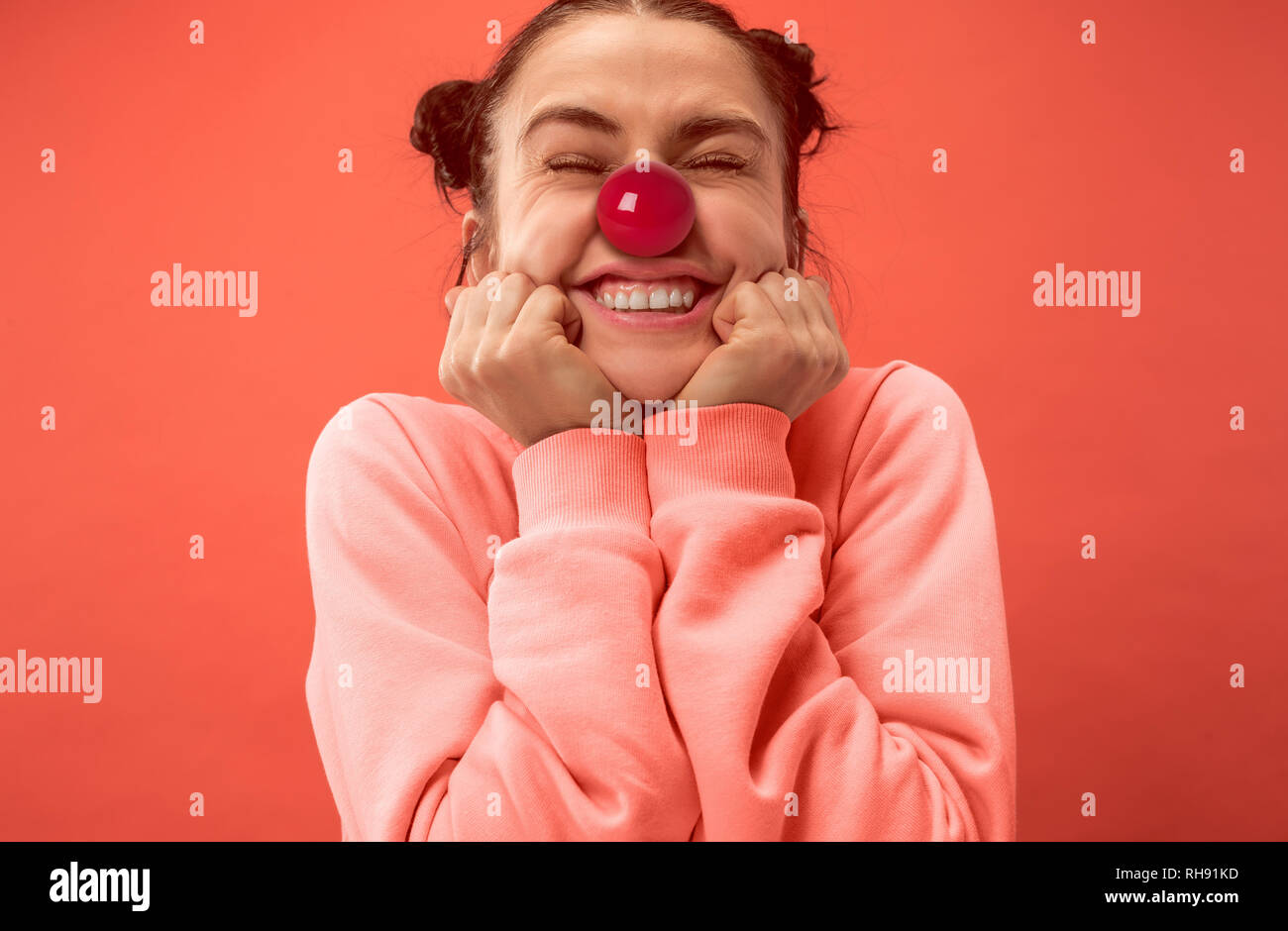 La felice sorpresa e donna sorridente sul naso rosso al giorno. Il clown, divertimento, party, celebrazione, divertente, gioia, vacanze, umorismo concept Foto Stock
