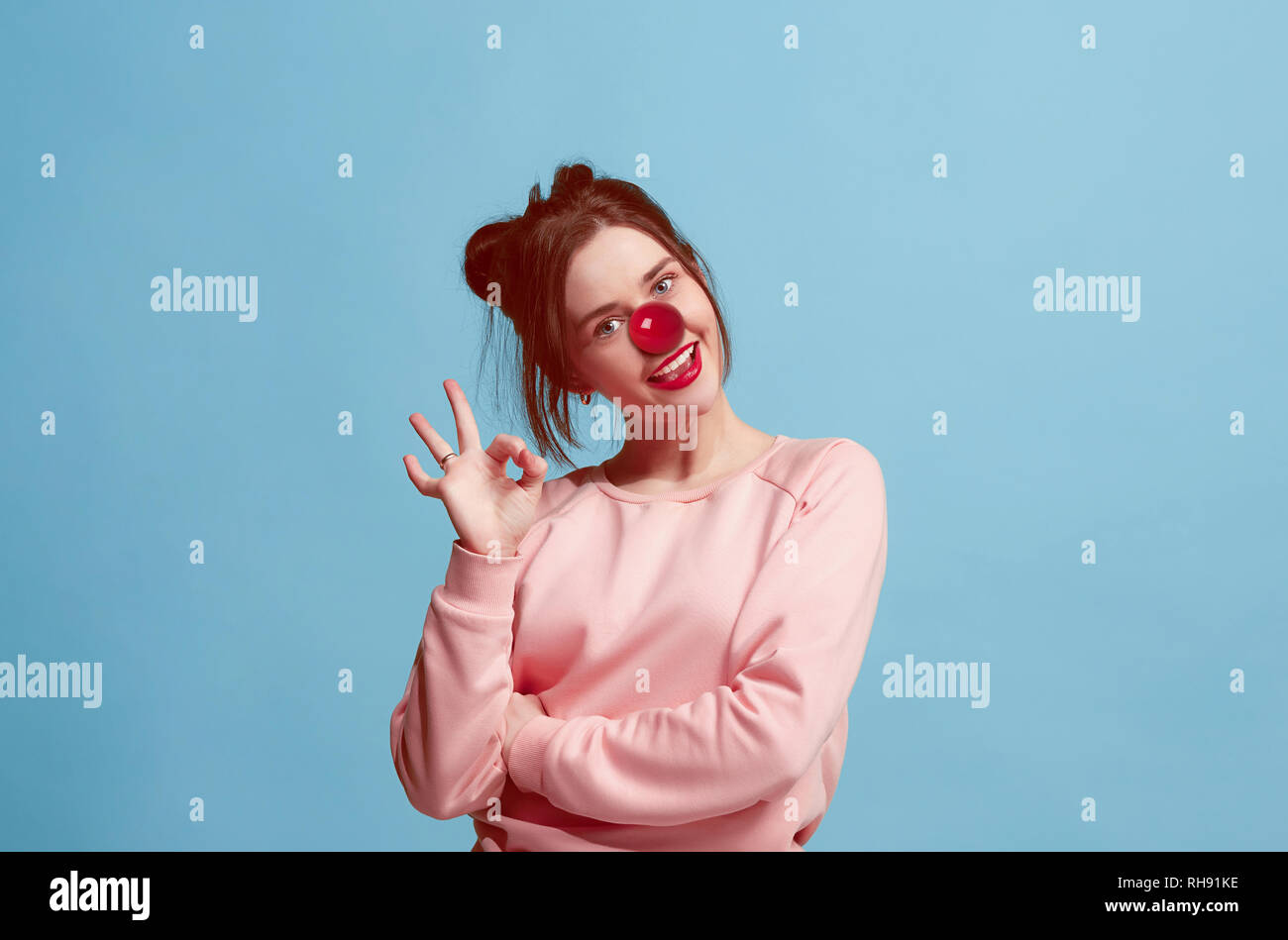 La felice sorpresa e donna sorridente sul naso rosso al giorno. Il clown, divertimento, party, celebrazione, divertente, gioia, vacanze, umorismo concept Foto Stock