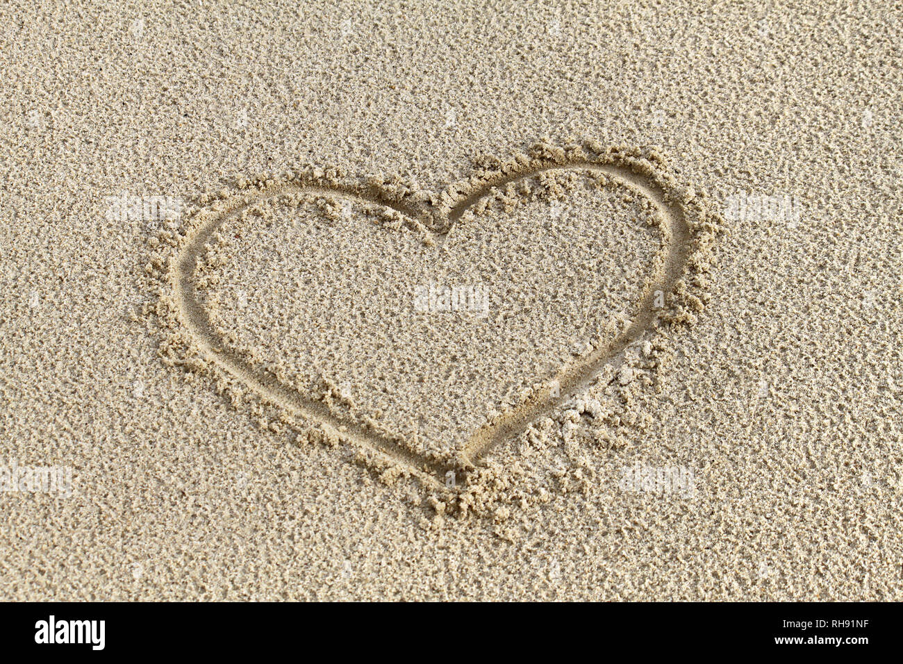 Disegno di cuore nella sabbia sulla spiaggia Foto Stock