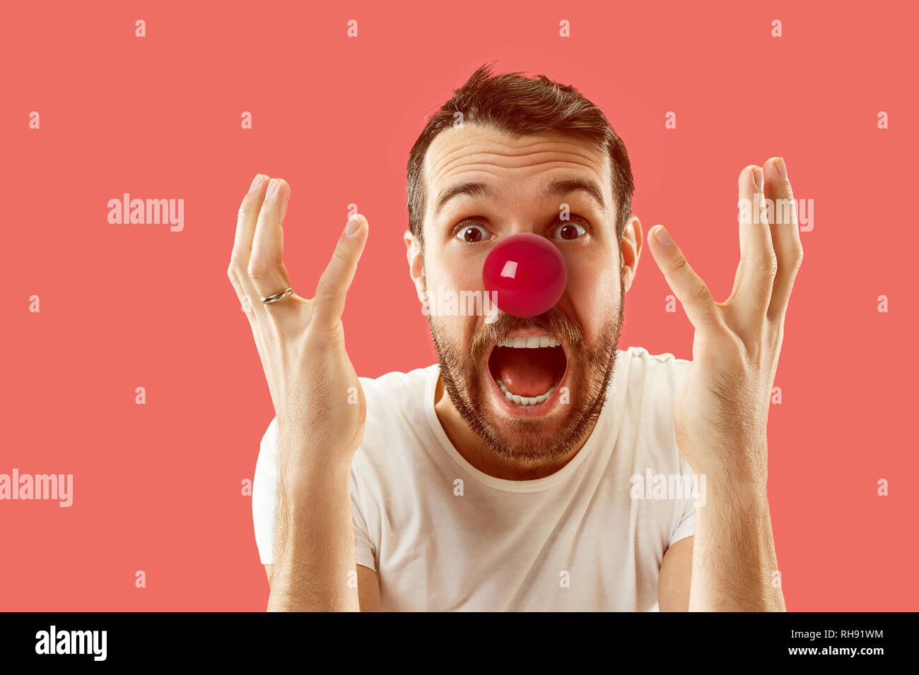 La felice sorpresa e uomo sorridente sul naso rosso al giorno. Il clown, divertimento, party, celebrazione, divertente, gioia, vacanze, umorismo concept Foto Stock