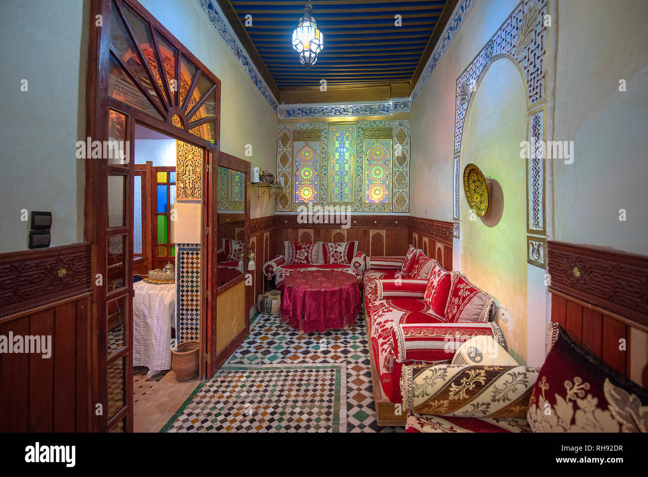 Cortile interno con pareti in piastrelle e pavimento di mosaico. Tradizionale e ornati arabesque colorate sculture a parete nel riad marocchino . All'interno Foto Stock