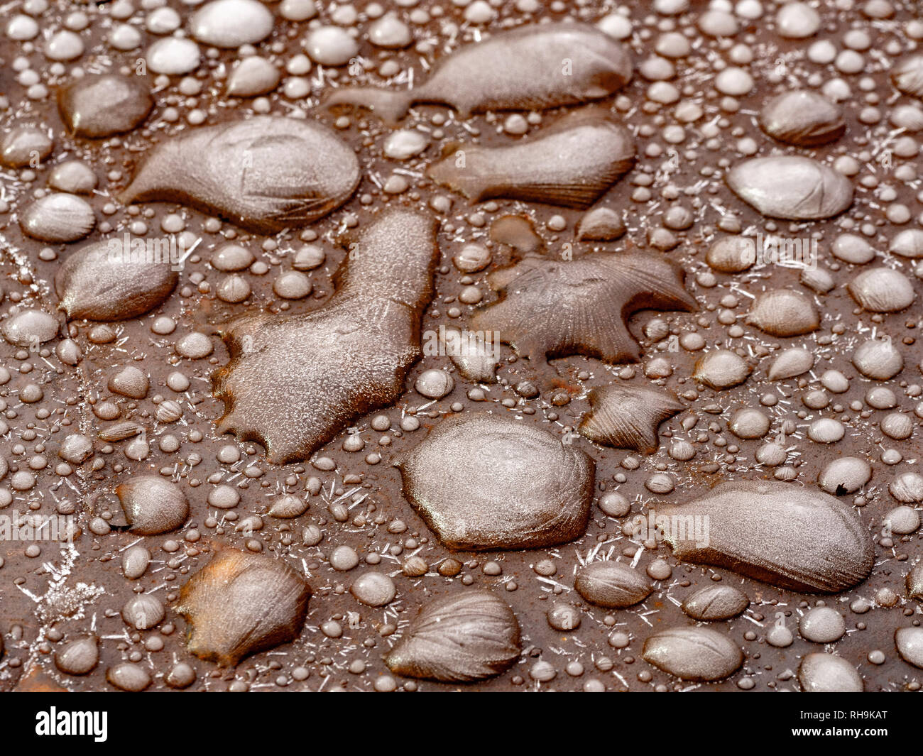 Congelate le goccioline di acqua su un acciaio tavolo da giardino. Foto Stock