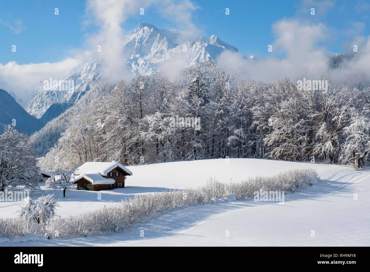 Paesaggio invernale, coperta di neve casa in legno, Hochkalter sul retro, Bischofswiesen, Berchtesgadener Land, Alta Baviera Foto Stock