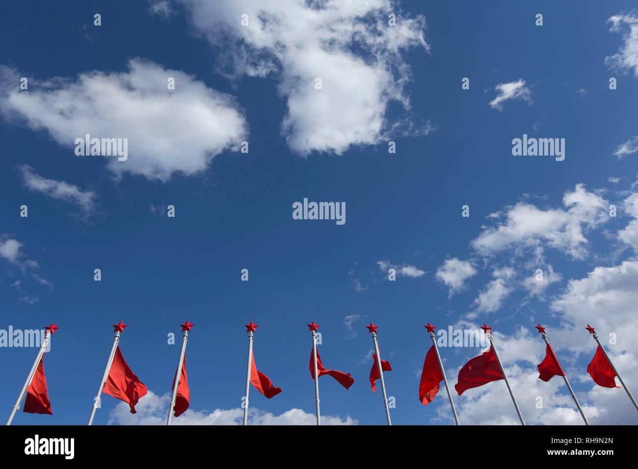 Bandiere rosse con la stella rossa al monumento di Mao Tse-tung, Lijiang, Cina Foto Stock