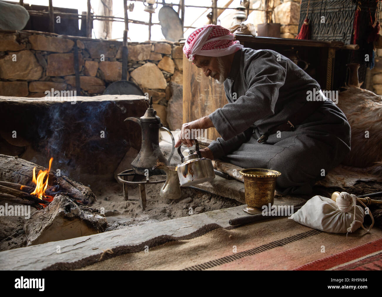 Arabia uomo la preparazione di caffè in un majlis, Provincia di Asir, Tanomah, Arabia Saudita Foto Stock