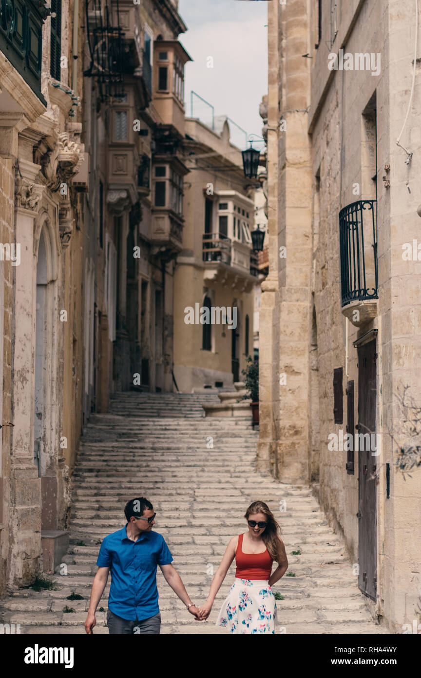 L uomo e la donna a piedi su per le scale sulla strada, la città vecchia della città Threee, Malta Foto Stock