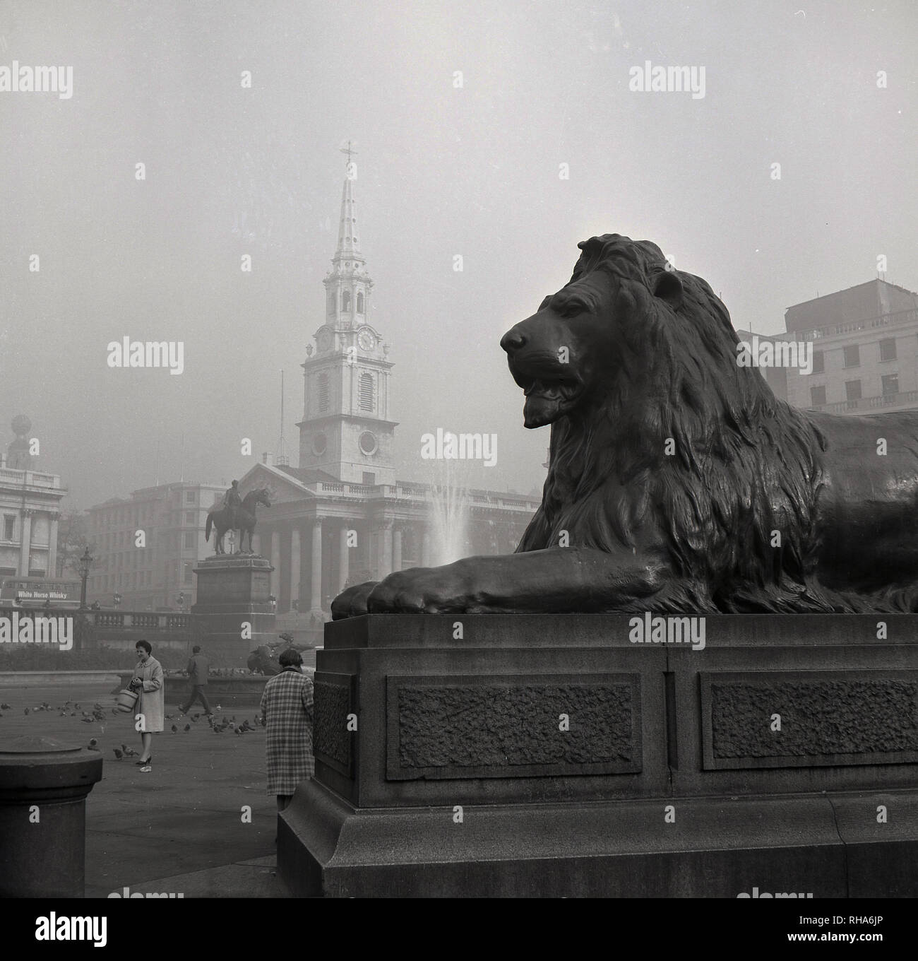 Degli anni Cinquanta, storico, uno del leone di bronzo statue che "riparo" "Nelson Colonna dell' a Trafalgar Square a Londra, Inghilterra, Regno Unito, progettato da Sir Edwin Landseer. Infatti la commissione per loro era stato in un primo tempo assegnato a allo scultore Tommaso Milnes. Ma essi erano considerati non abbastanza impressionante e così il famoso pittore Edwin Landseer è stato chiesto di progettare il Lions nel 1858. Amati e ben scalato...sono tra le più grandi sculture in bronzo nel Regno Unito. Foto Stock