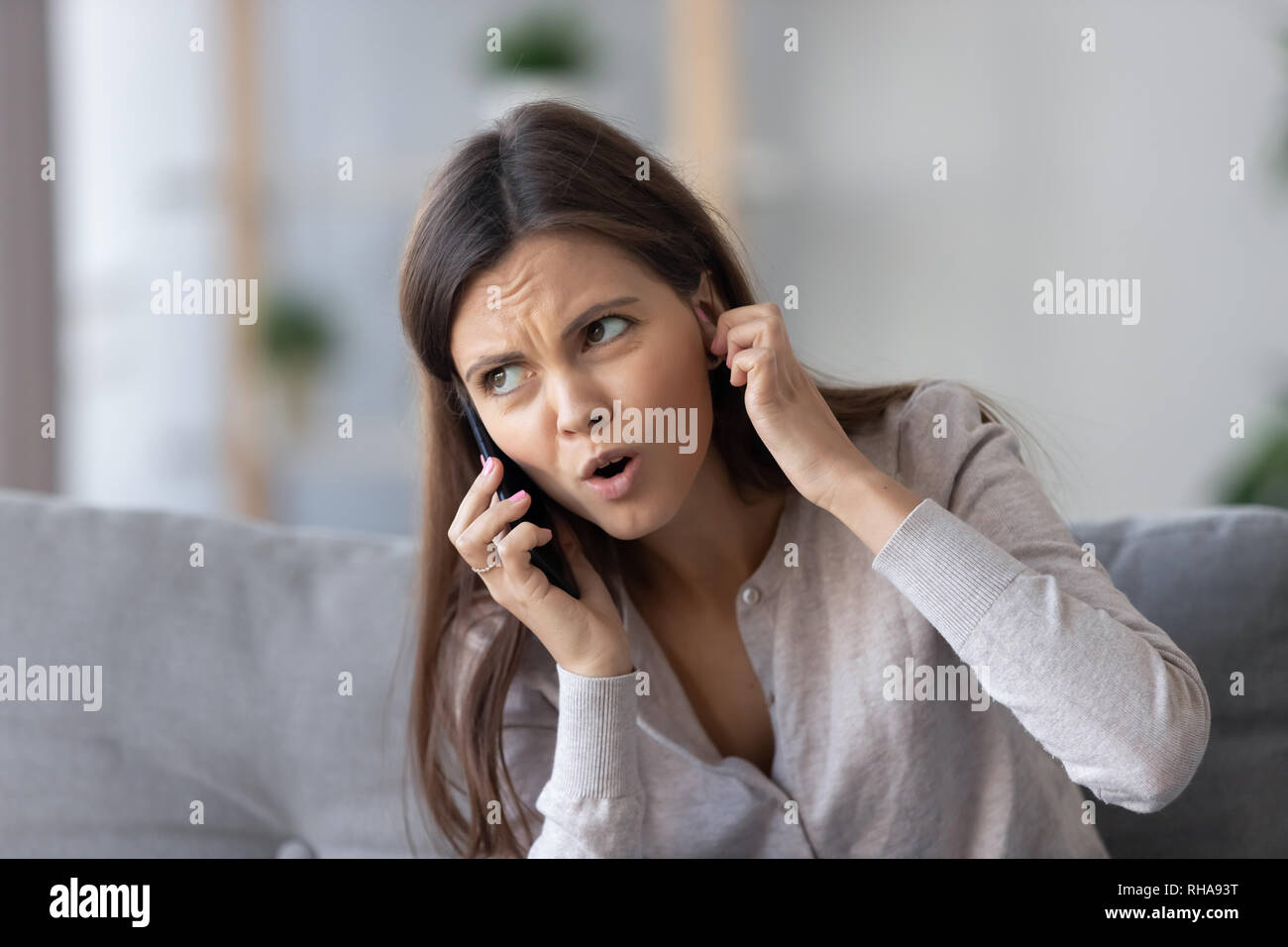 Infastiditi giovane donna parlando al telefono non audizione cattivo segnale Foto Stock