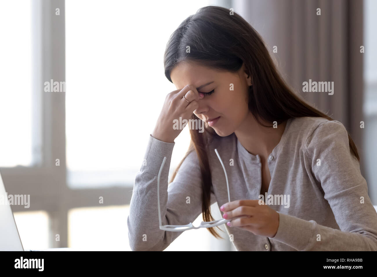 Oberati di lavoro stanco donna giovane studente azienda bicchieri sensazione di affaticamento della vista Foto Stock