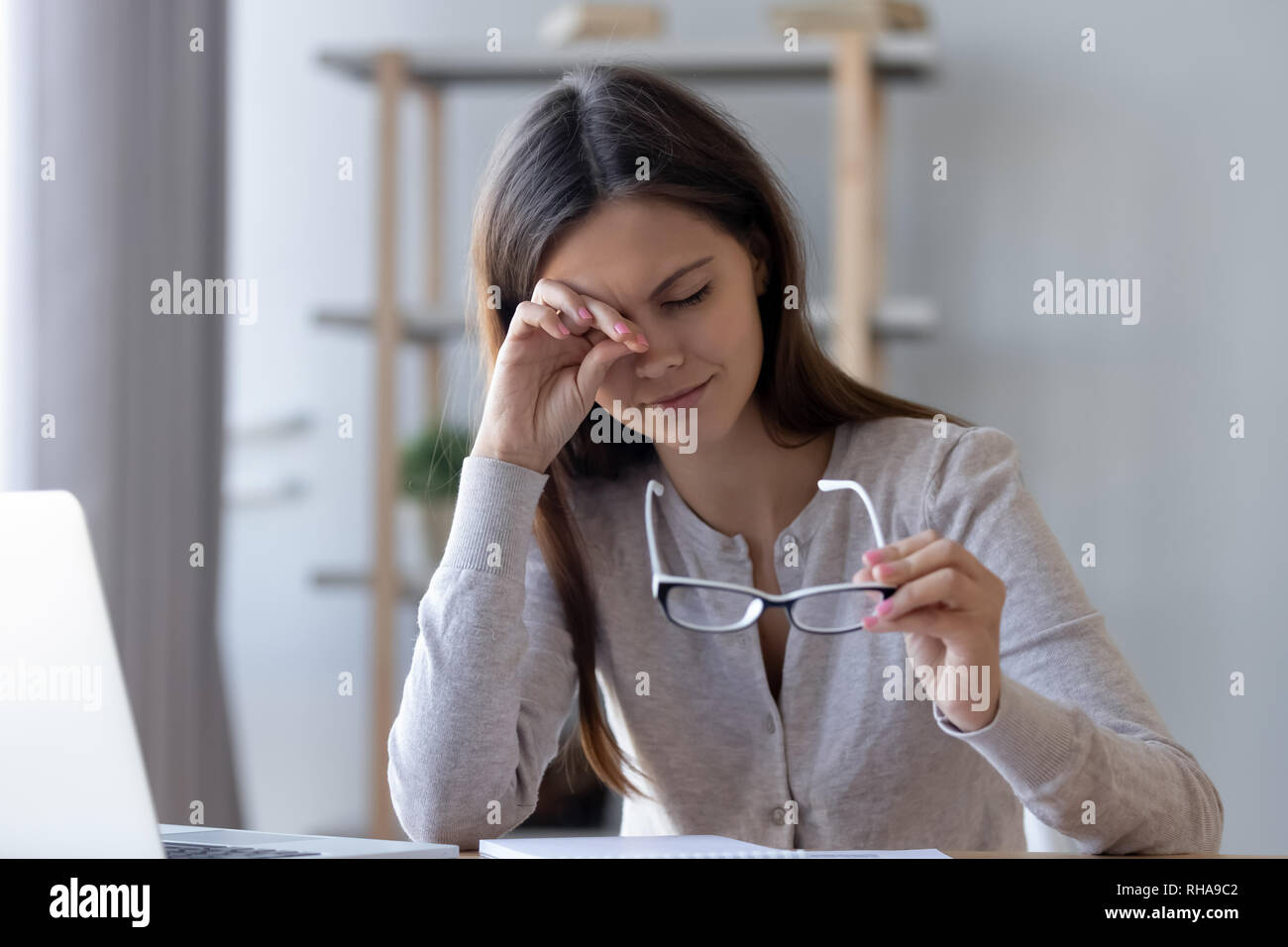 Stanco donna strofinarsi gli occhi di sensazione di fatica occhiali da computer di lavoro Foto Stock