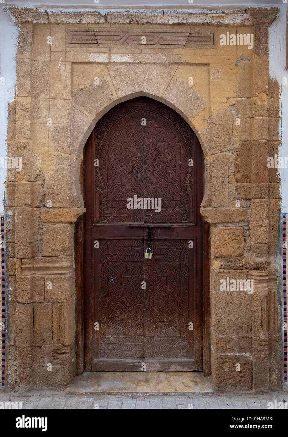 Tipico, vecchio, marrone intricate sculture, costellata, riad marocchino porta e porta-cornice e la vecchia casa in Marrakech, Marocco Foto Stock