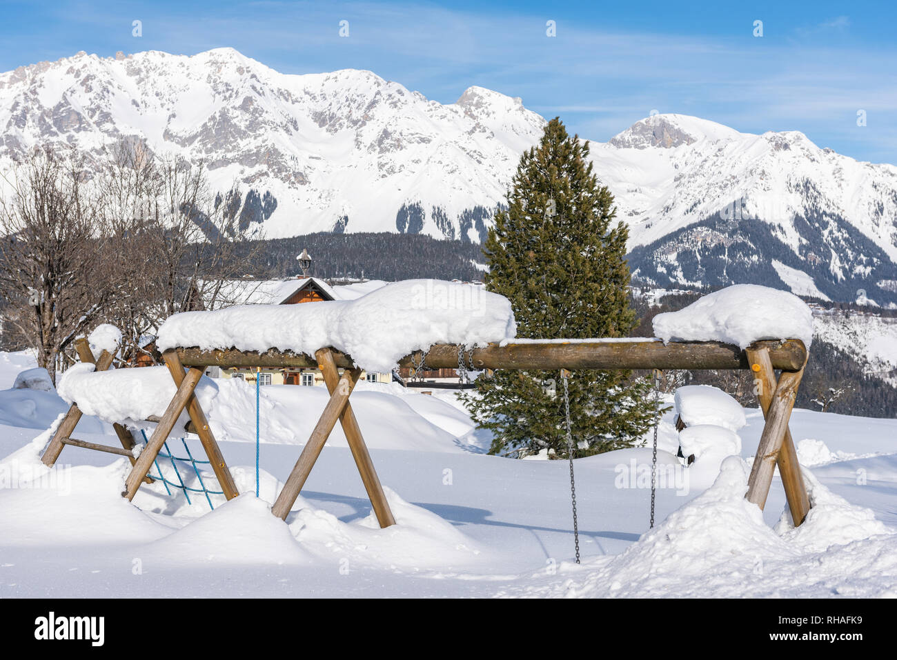 Parco giochi per bambini in inverno sotto la neve nel paesaggio di montagna. Massiccio Dachstein, Liezen District, Stiria, Austria, Europa Foto Stock