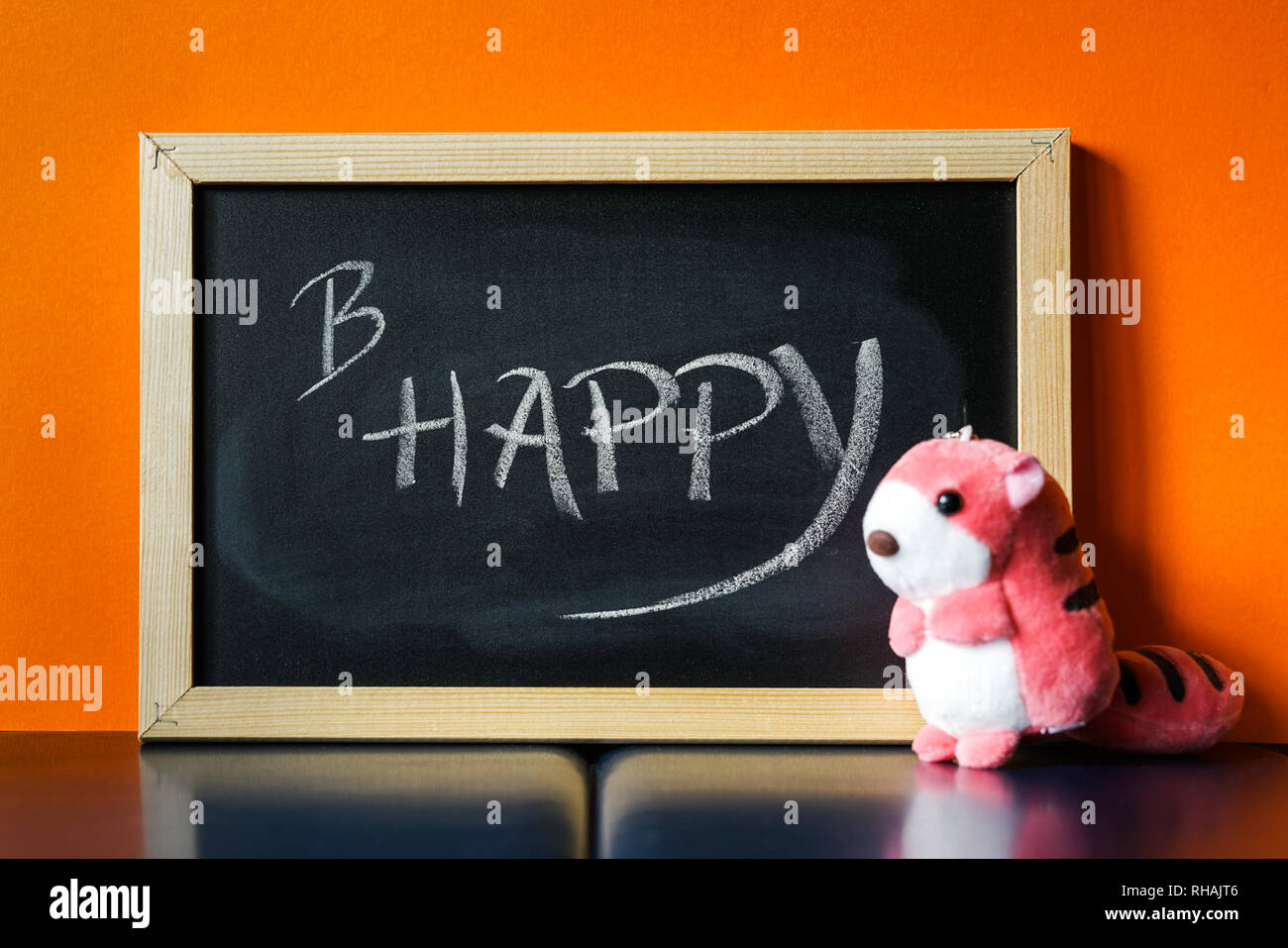 Scheda nero con testo B Happy scritto su Chalk e una rosa giocattolo morbido accanto ad esso Foto Stock