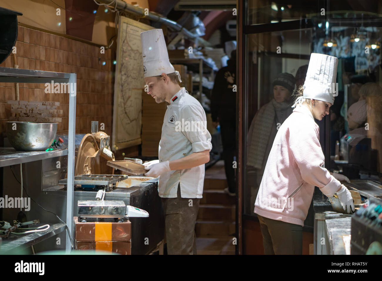 Imprenditore mano separando le fave di cacao per la produzione mentre si sta in piedi in una tabella in un cioccolato artigianale rendendo la fabbrica Foto Stock