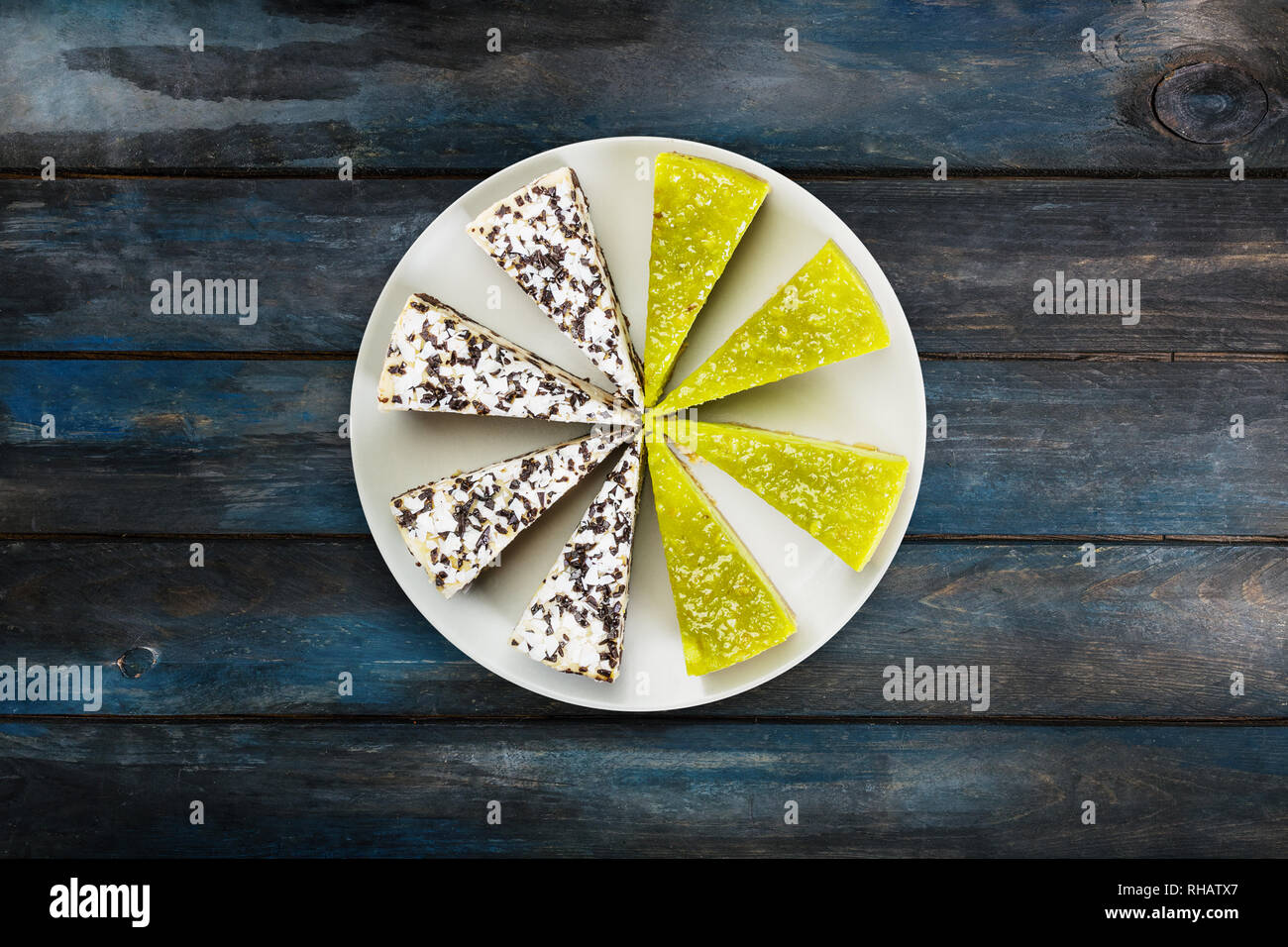 Due tipi di cioccolato cheesecake e calce su un piatto bianco, su un bellissimo sfondo di legno. Vista dall'alto. Foto Stock