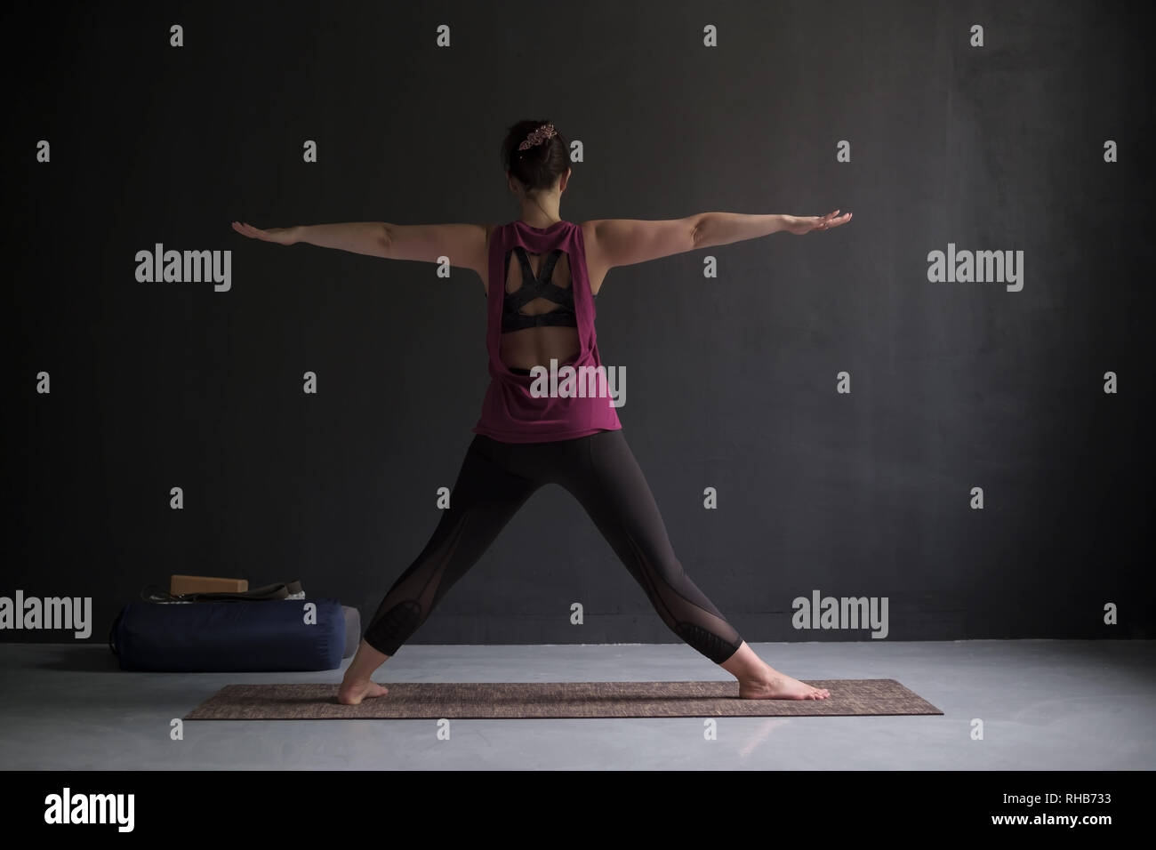 Bellissimo modello facendo esercizi yoga. Preparazione per fare trikonasana postura. Foto Stock