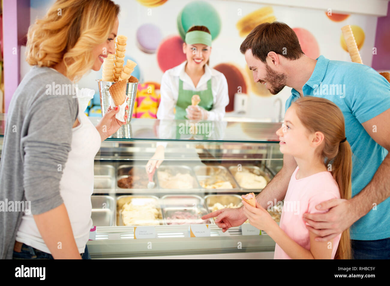 Famiglia con la figlia sceglie gusti di gelato in pasticceria Foto Stock