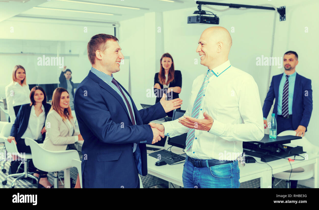 Due uomini d'affari di successo si stringono la mano in office confermando il partenariato Foto Stock