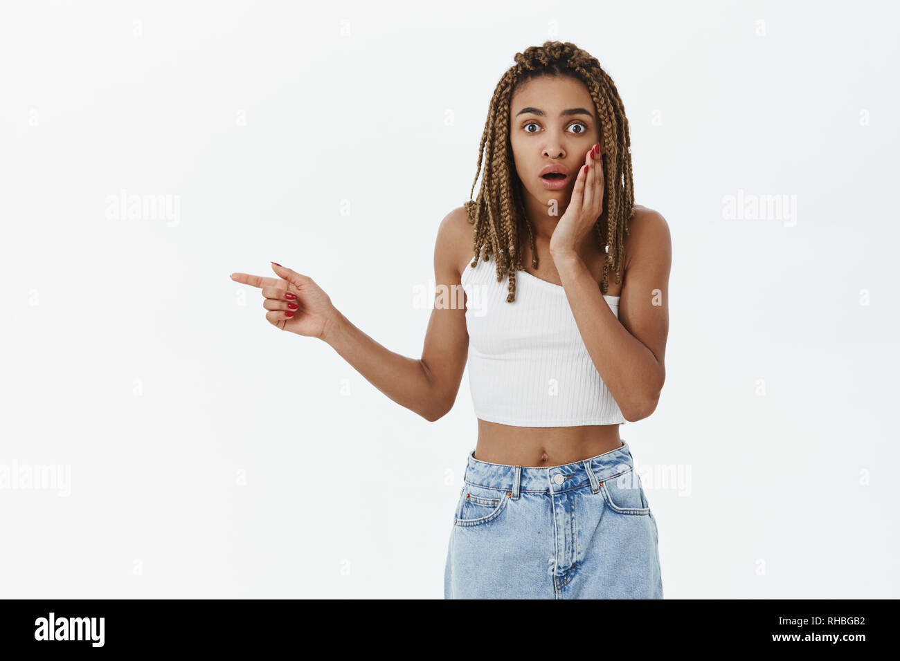 Ritratto di donna scioccato puntando verso l uomo ha ottenuto in difficoltà in piedi sorpreso e stordito che indica a sinistra in possesso di Palm sulla guancia e affannosa preoccupata e Foto Stock