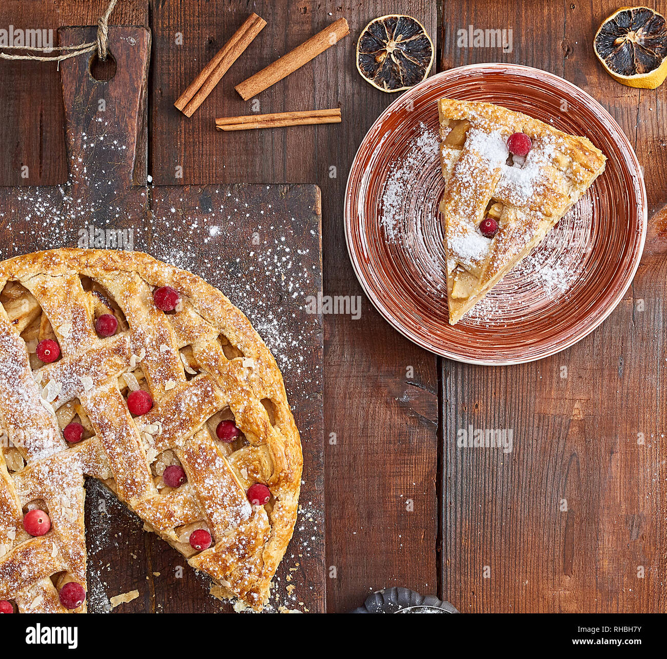 La torta di mele su un vecchio rettangolare marrone tagliere spolverati con zucchero a velo, vista dall'alto Foto Stock