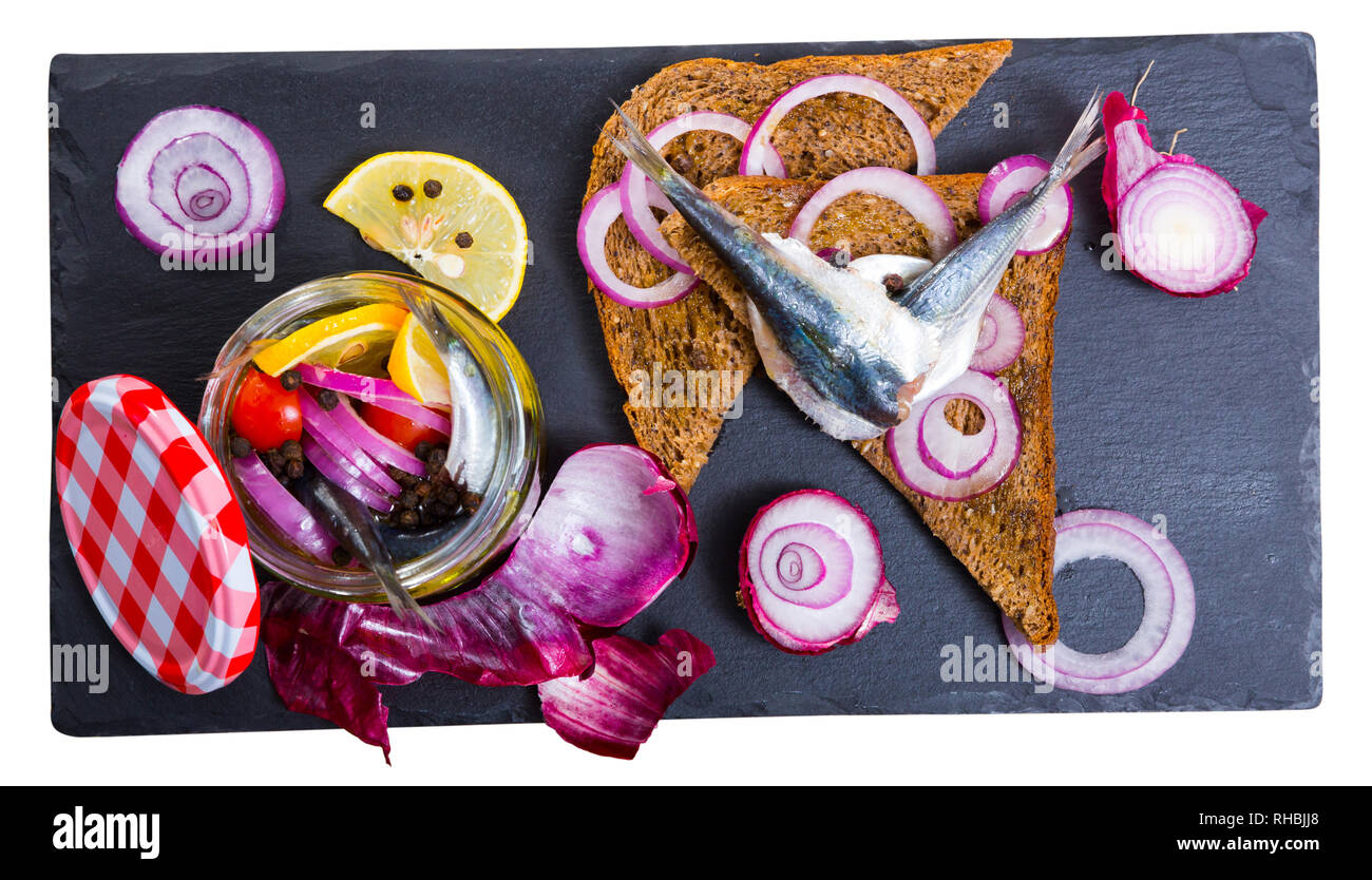 Decapati spratti in casalingo marinata di olio d'oliva, aceto, limone, sale marino con spezie, la cipolla e le barbabietole servita con pane di segale. Isolato su bianco bac Foto Stock