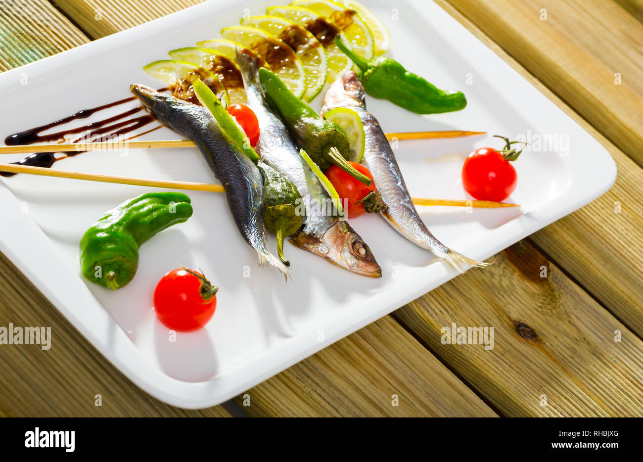 Lo spratto alla griglia con verdure fresche, servita con calce e pasta di aceto balsamico Foto Stock