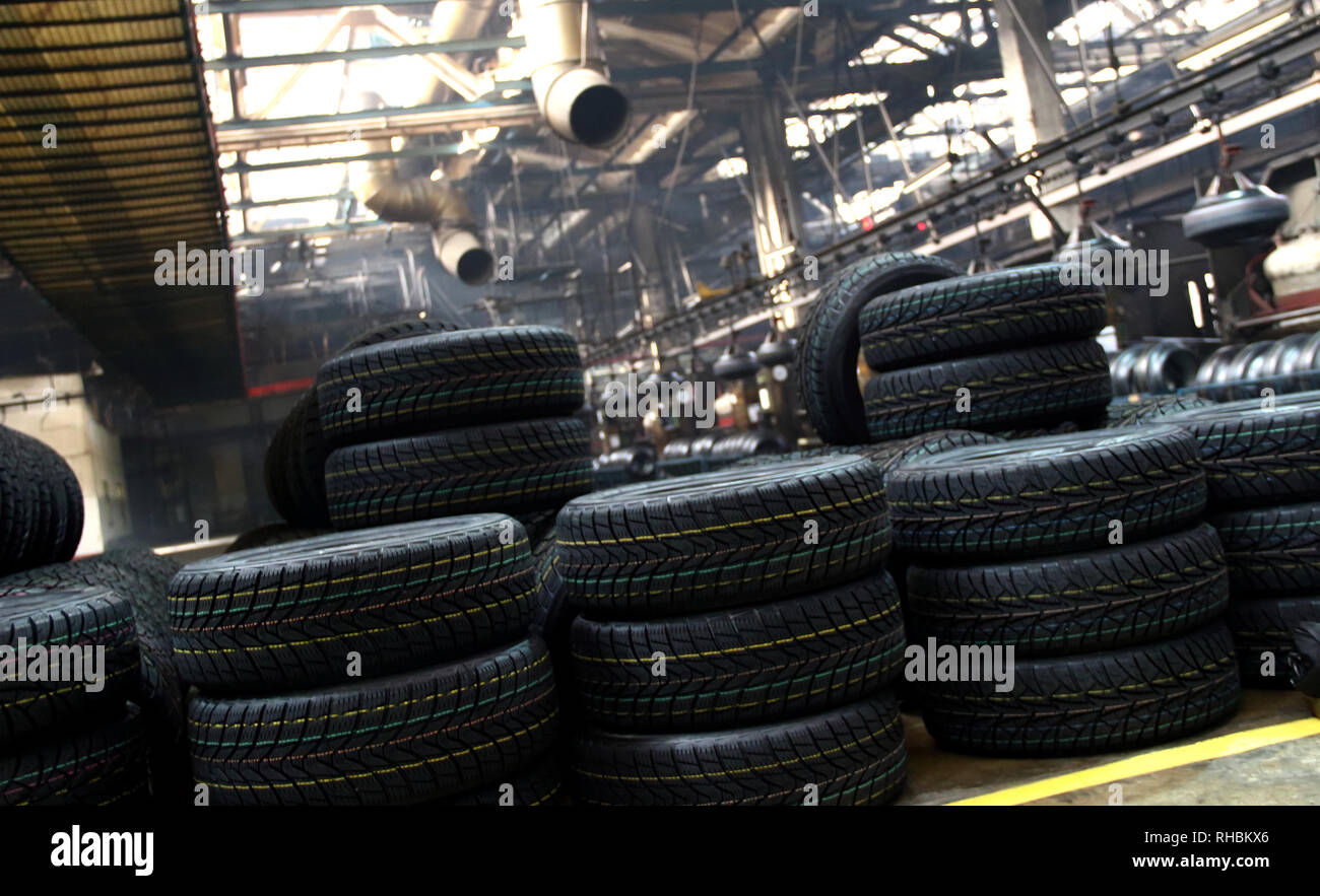 La produzione di pneumatici impianto sito. Auto nuove pneumatici impilando sul pavimento del workshop Foto Stock