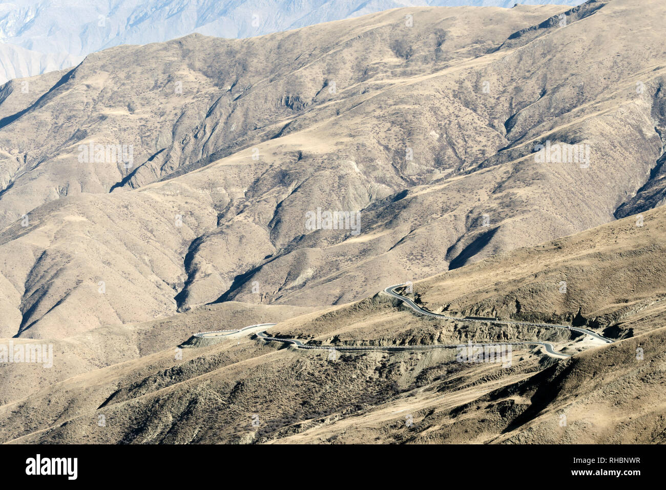 Pavimentato moderna strada di montagna con aspre montagne sullo sfondo, Tibet Foto Stock