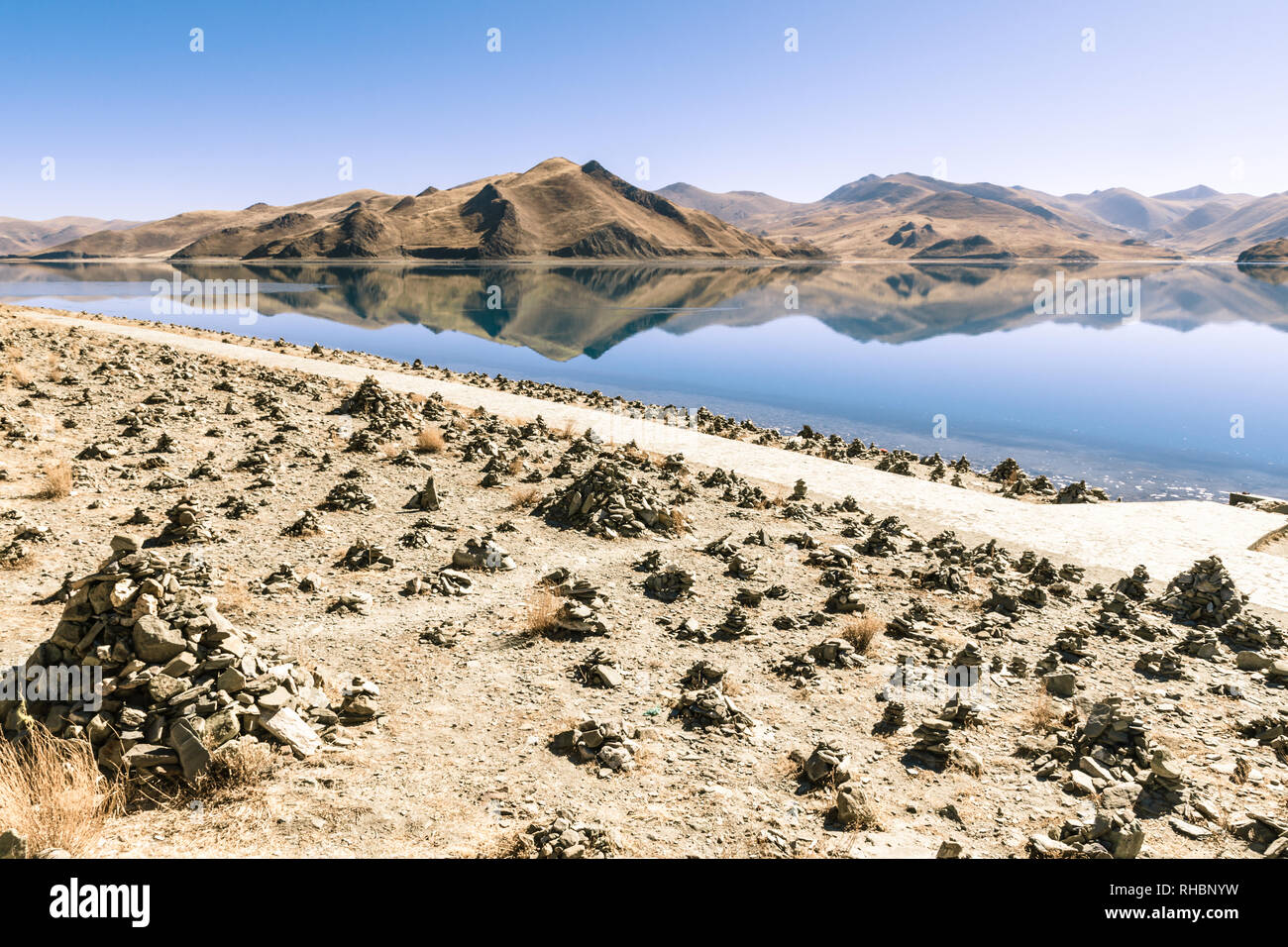 Cairns accanto al lago Yamdrok, Tibet Foto Stock