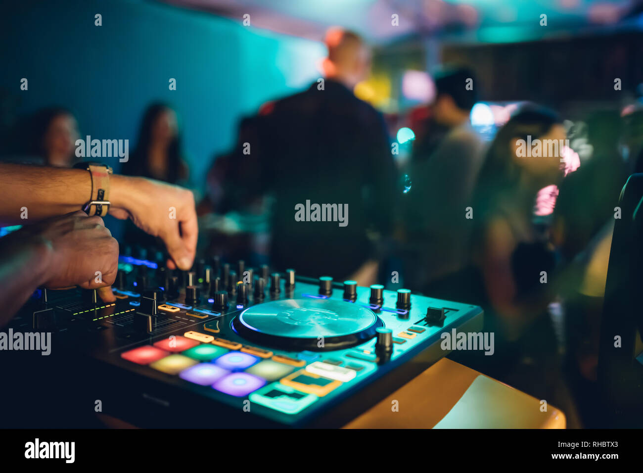 DJ suona live set e mixare la musica sulla console di piattaforma girevole nella fase nei night club. Disc Jokey le mani su un mixer audio station al club di partito. DJ Mixer Foto Stock