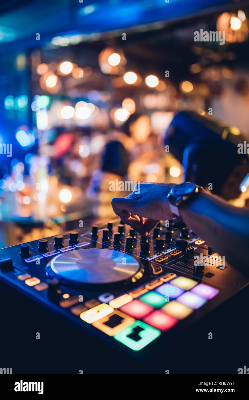 DJ suona live set e mixare la musica sulla console di piattaforma girevole nella fase nei night club. Disc Jokey le mani su un mixer audio station al club di partito. DJ Mixer Foto Stock