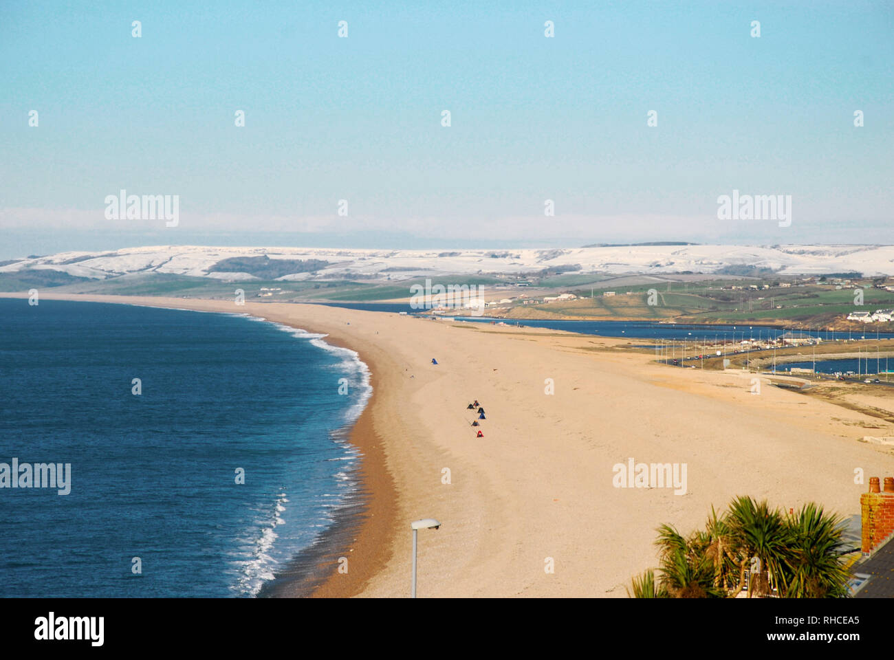 Isola di Portland, Dorset. Isola di Portland. 2° febbraio 2019. Il sole scende su Chesil Beach e sulla neve sulle colline costiere, vicino a Weymouth Credito: stuart fretwell/Alamy Live News Foto Stock