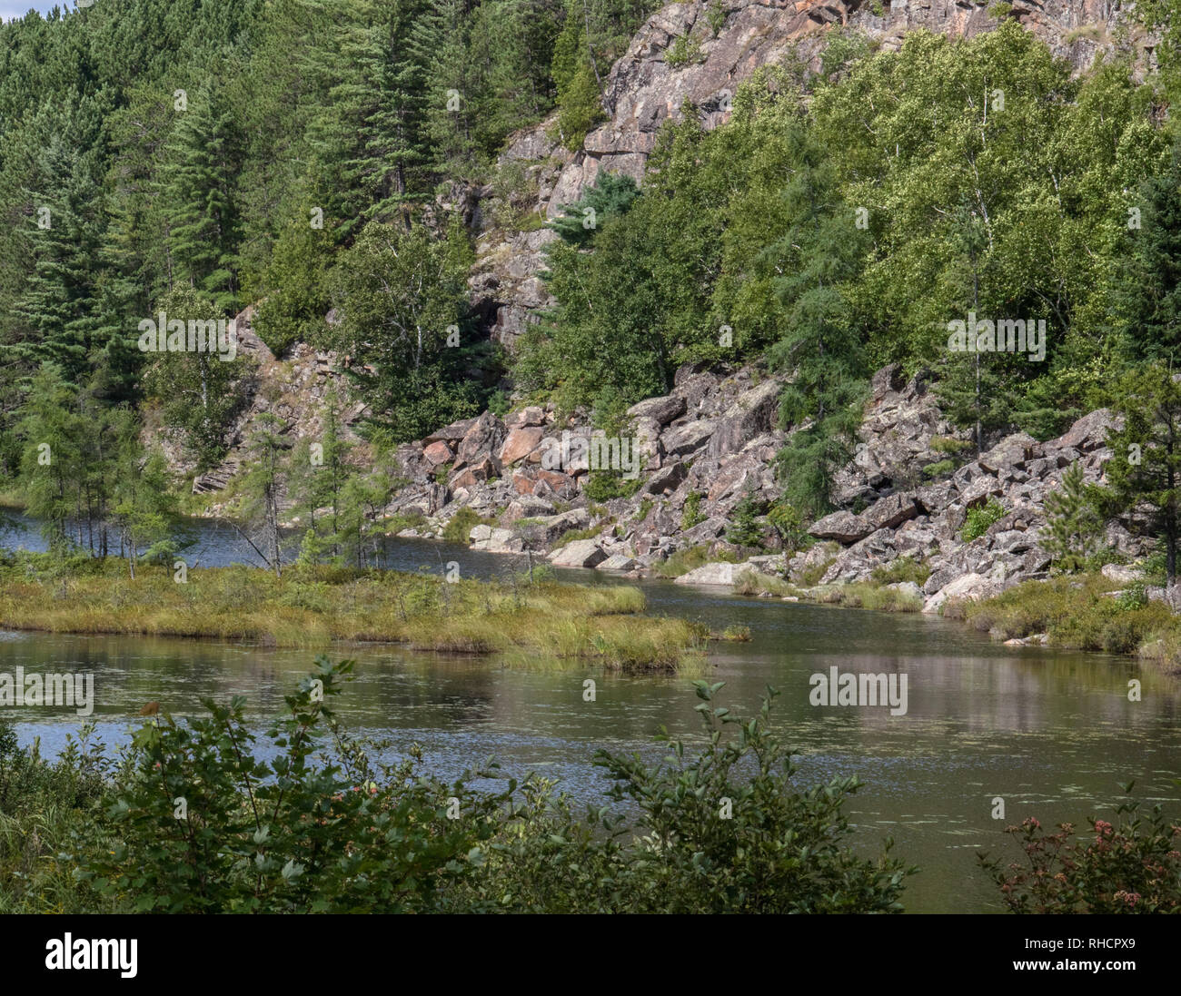 Torrente nel Parco Algonquin circondato da ripide pareti rocciose e alberi sempreverdi Foto Stock