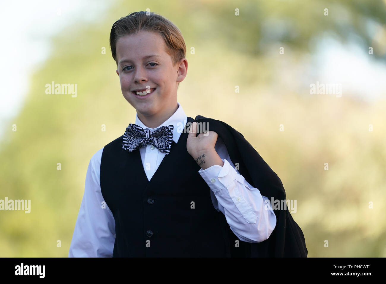 Un ragazzo in un vestito con un filtro bow tie pone per un ritratto. Foto Stock